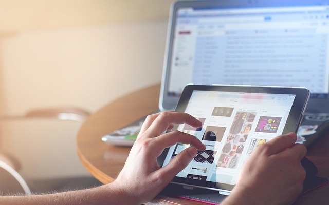 image with a monitor and hands scrolling on the monitor